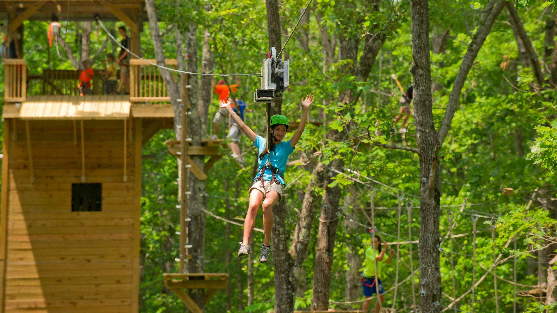 Person ziplining in a forest.
